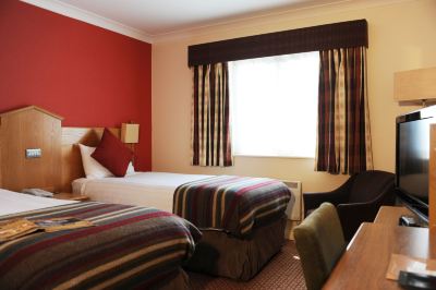 a hotel room with two beds , one on the left and one on the right side of the room at Village Hotel Liverpool
