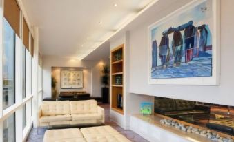 a modern living room with a white couch , coffee table , and bookshelves , as well as a painting on the wall at Holiday Inn Salisbury - Stonehenge