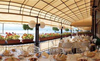 a dining room with tables and chairs arranged for a group of people to enjoy a meal at Hotel Duomo