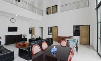 a spacious living room with high ceilings , a dining area , and a staircase leading to the second floor at Adel Guest House