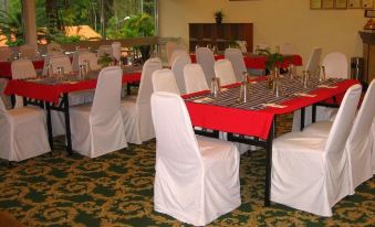 a dining room with several tables and chairs arranged for a large group of people at Shahzan Inn Fraser's Hill