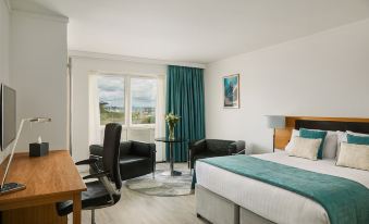 a modern hotel room with a large bed , black furniture , and a view of the ocean at Langstone Quays Resort