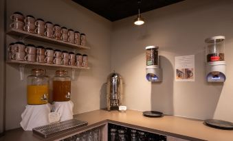 a well - stocked bar with shelves holding various items such as coffee mugs , bottles , and a dispenser at Hotel Hvide Falk
