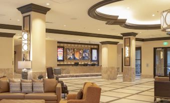 a hotel lobby with a reception desk and chairs , along with a large screen displaying movie posters at Soboba Casino Resort