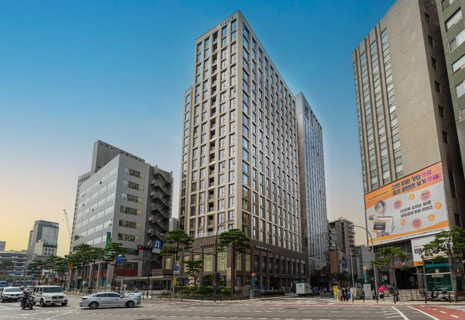 a large building with numerous windows on the side and one at the front intersection at HOMES Stay Myeongdong
