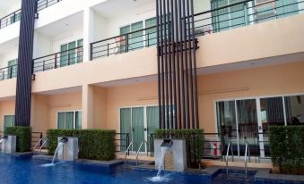 a modern apartment building with a swimming pool and surrounding facilities , such as umbrellas and fountains at The O Valley Hotel