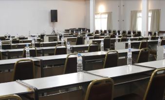 an empty classroom with rows of desks and chairs , all facing the same direction in a large room at Hotel Fazenda Sete Lagos