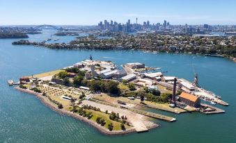 an aerial view of a city with a large body of water and a harbor area at Cockatoo Island Accommodation