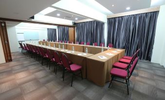 a conference room with a long table , multiple chairs , and blue curtains , ready for a meeting at Sem9 Senai "Formerly Known As Perth Hotel"