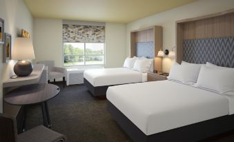 a hotel room with two beds , a window , and a dining table , all neatly arranged at Holiday Inn Allentown-Bethlehem