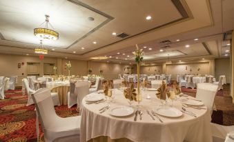 a large dining room with round tables and chairs arranged for a formal event , possibly a wedding reception at Hotel Mtk Mount Kisco