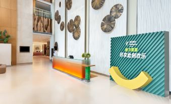There is a sign and various decorative items in front of the lobby entrance at Holiday Inn Shanghai Pudong
