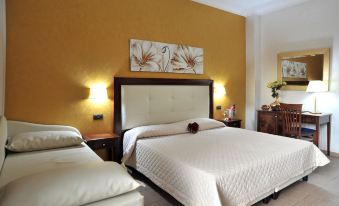 a hotel room with a large bed , white bedding , and two lamps on either side of the bed at Hotel Flora