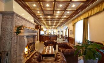 a luxurious hotel lobby with high ceilings , wooden floors , and a large fireplace , decorated with comfortable seating areas at Festa Winter Palace Hotel