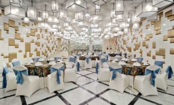 a large banquet hall with tables and chairs set up for a formal event , possibly a wedding reception at Radisson Hotel New Delhi Paschim Vihar