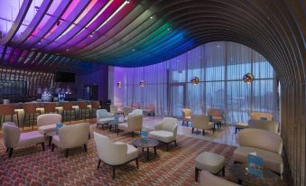 a modern lounge area with colorful ceiling , white furniture , and large windows , under a curved ceiling decorated with black lines at Doubletree by Hilton Istanbul Umraniye