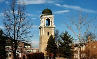 a snowy landscape with a tall clock tower in the background , surrounded by trees and buildings at Residence Inn Denver Tech Center