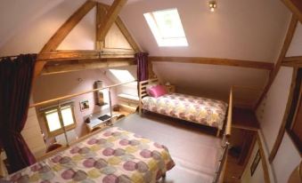 a cozy bedroom with two beds , one on each side of the room , and a wooden ceiling at La Grange