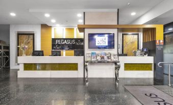 "a modern office reception area with a large tv screen and a white counter , featuring the text "" pegasus "" on top of the desk" at Pegasus Apart'Hotel