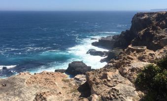 a rocky coastline with waves crashing against the shore , creating a picturesque view of the ocean at Victoria House