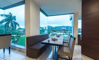 a modern dining area with a long table and several chairs , set in front of large windows overlooking a mountainous landscape at Hotel Lake View