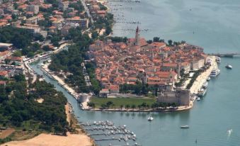 an aerial view of a city surrounded by water , with boats docked in the harbor at Villa Rustica Dalmatia