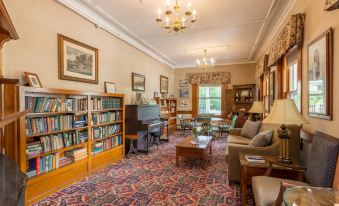 a cozy living room with a grand piano in the center , surrounded by comfortable couches and chairs at Eagle Mountain House and Golf Club