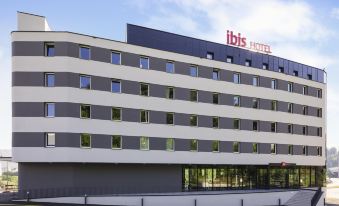 a large hotel building with a white and gray exterior , located in a city setting at Ibis Baden Neuenhof