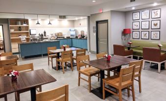 a restaurant with wooden tables and chairs , a dining area with a counter , and various appliances at Comfort Inn & Suites