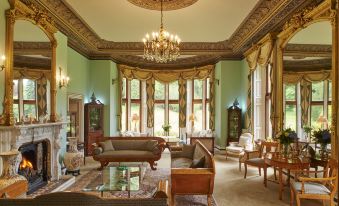 a large , ornate living room with a grand chandelier hanging from the ceiling , creating an elegant atmosphere at Pale Hall Hotel