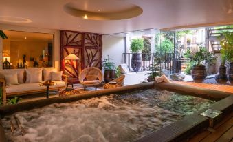 a large indoor pool surrounded by lounge chairs , where people are relaxing and enjoying their time at Les Etangs de Corot