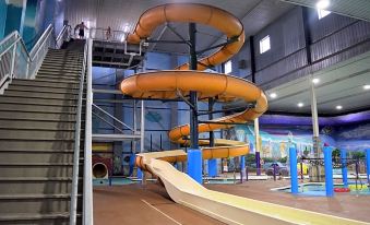 an indoor water park with multiple slides and a staircase leading to the upper level at Metropolis Resort - Eau Claire