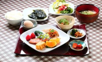 a table is set with a variety of dishes , including sushi and salad , in a restaurant setting at Flower Garden