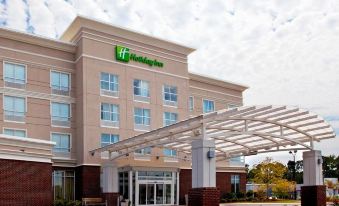 "a large hotel with a covered entrance and a sign that says "" holiday inn "" on the side" at Holiday Inn Statesboro-University Area