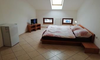 a bedroom with a large bed , two windows , and a television on a wooden stand at Hotel 28