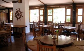 a large dining room with wooden tables and chairs arranged for a group of people to enjoy a meal together at Country Inn Masindi