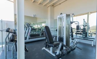 a well - equipped gym with a variety of exercise equipment , including weight machines , treadmills , and benches at Casa Andina Standard Talara