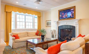 a cozy living room with a fireplace , white couches , and a flat - screen tv mounted on the wall at Mills Park Hotel