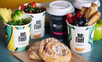 a table with three cups of coffee and a pastry , along with a plant in the background at Aloft Ocean City