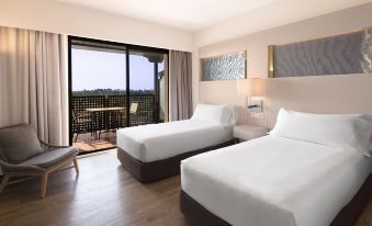 a hotel room with two beds , one on the left and one on the right side of the room at DoubleTree by Hilton Islantilla Beach Golf Resort