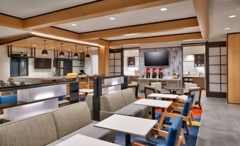 a modern restaurant with wooden floors and furniture , including tables and chairs , as well as a bar area at Hyatt House Provo/Pleasant Grove
