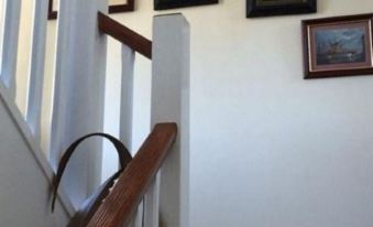 a white staircase with a wooden handrail and several framed pictures hanging on the wall at Number 19 Guest House - 4 Miles from Barrow in Furness - 1 Mile from Safari Zoo