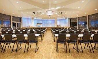 a large conference room with rows of chairs arranged in a semicircle , and a podium at the front of the room at Scandic Ishavshotel