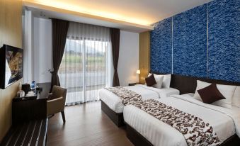 a hotel room with two beds , one on the left and one on the right side of the room at Horison Tirta Sanita Kuningan
