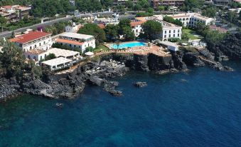 aerial view of a resort on the coast , featuring a pool surrounded by lush greenery at Grand Hotel Baia Verde
