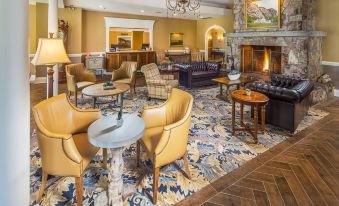 a well - decorated hotel lobby with various seating options , including chairs and couches , as well as a fireplace at White Mountain Hotel and Resort