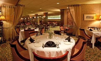 a formal dining room in a hotel , with tables set for a dinner party and elegant decor at Holiday Inn Johnstown-Downtown