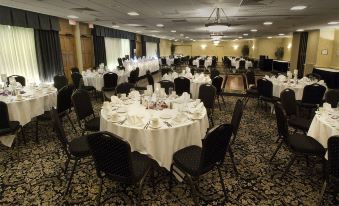 a large banquet hall with multiple tables and chairs set up for a formal event at Buffalo Airport Hotel