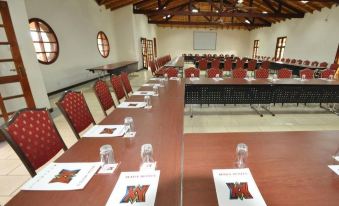 a conference room set up for a meeting , with rows of chairs arranged in a semicircle and a podium at Kilima Safari Camp