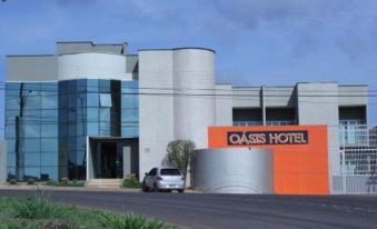 "a modern building with a large orange sign that reads "" oasis hotel "" on the side" at Oasis Hotel